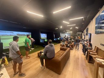 Golfers gathered in the simulator and lounge area at Clubhouse Hawaii