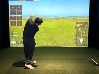 Golfer swinging in a TrackMan simulator at Clubhouse Hawaii