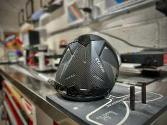 Driver head displayed on a club fitting workbench